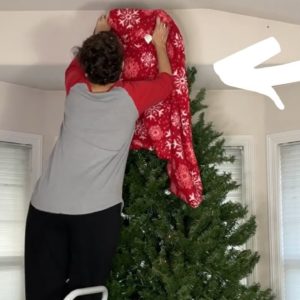 She wraps a blanket around her Christmas tree for a hilarious decorating idea!